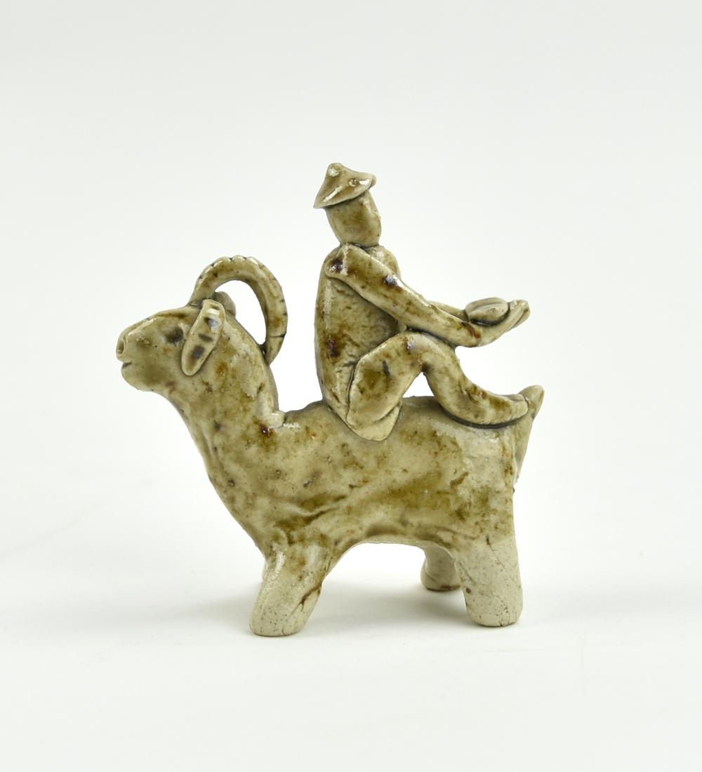 Chinese Yaozhou Ware Boy Riding Goat, Jin Dynasty: Chinese ,Jin Dynasty, a celadon glazed ornament, with a figure seating at the back of a mountain goat H: 2.5"(6.4cm) D: 2.4"(6.2cm)Condition: in overall good condition, free of damage