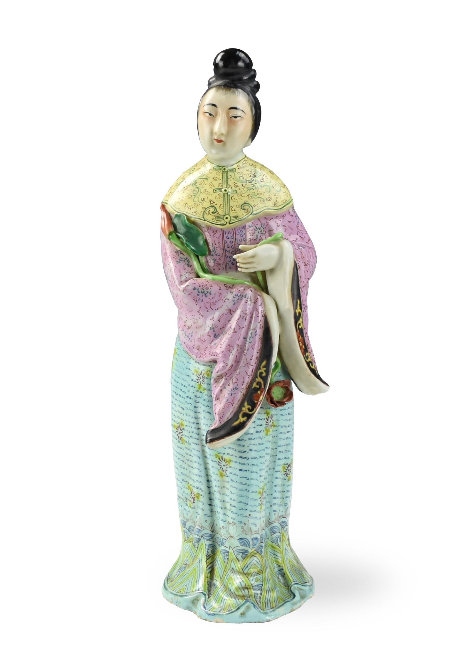 Chinese Famille Rose Figure of Lady, 20th C.: Chinese ,20th C, standing and dressed in flowing robes decorated with various floral patterns, the shoulder covered with a green floral-medallion cape, the finely modeled hands holding lotus flower be