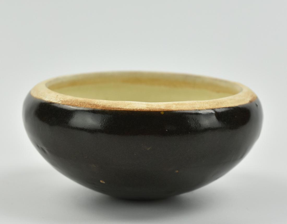 Chinese Black Ware Bowl, Tang Dynasty: a Chinese ,Tang Dynasty, rounded "zisu" (black and white) bowl, exterior in dark brown glaze, with white crackled glaze to the interior, mouth rim unglazed H: 2"(5.1cm) D: 4.4"(11.2cm) Provenance: col