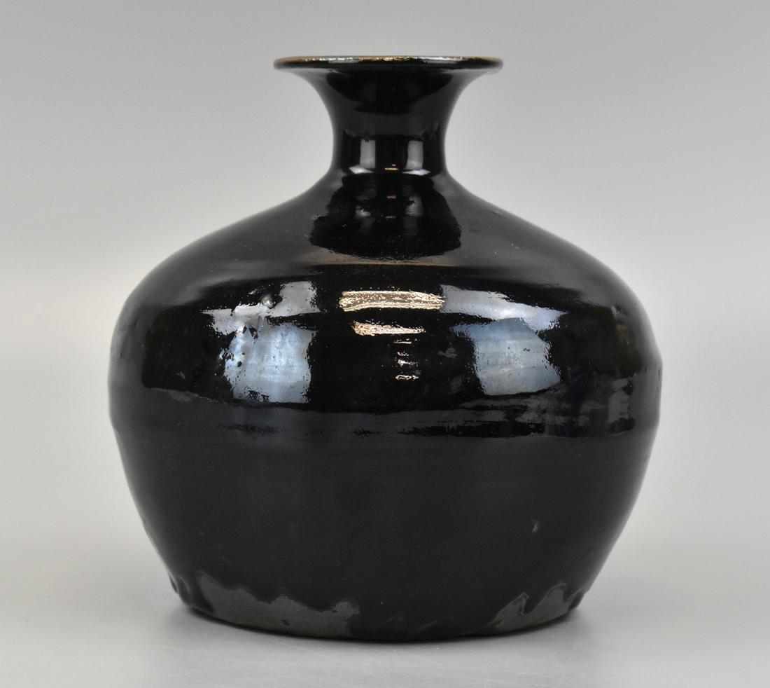 Chinese Black Glazed Tulu Vase, Ming Dynasty: A Chinese black glazed Tulu vase, Ming Dynasty , Squat domed body with dramatically sloping shoulder to a narrow waisted neck, to a very wide lipped rim. A lustrous black glaze pools at the base where