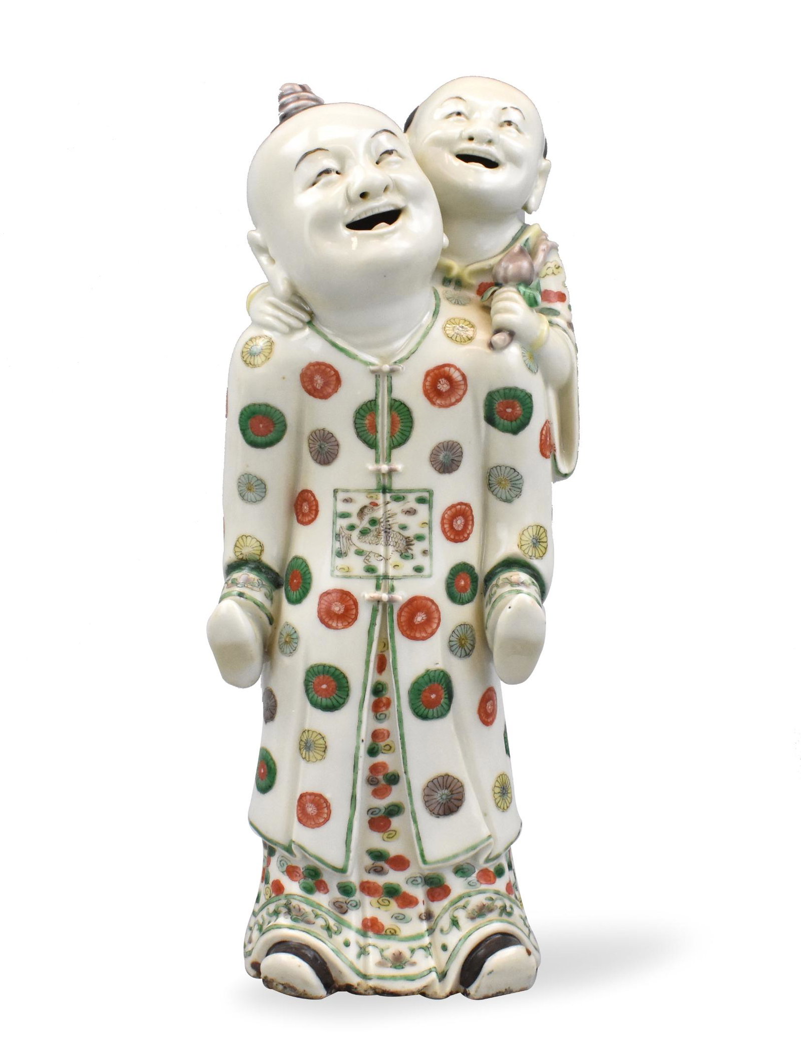 Chinese Famille Verte Porcelain Figure,Kangxi P.: A Chinese famille verte porcelain sculpture of two figures, Kangxi Period. Man in front gives a "piggyback" ride to a smaller men, both are smiling. Both have robes, with smaller man holding a flower 