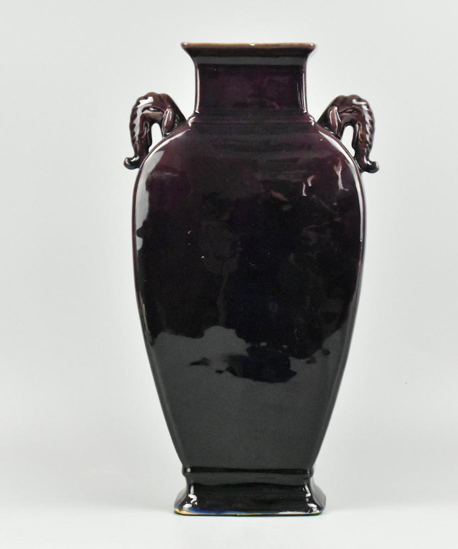 Chinese Purple Glazed Elephant Handle Vase, 20th C: A Chinese purple glazed vase with elephant trunk handles, dating from the 20th century. From a rectangular base the vase rises outwards with squared edges on the two flat sides, with elephant handles 