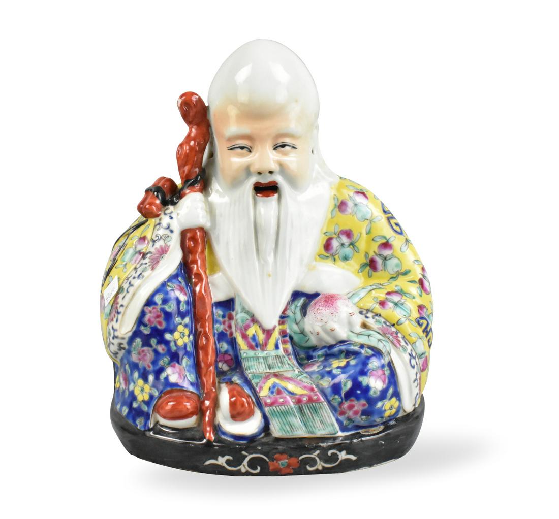 Chinese Famille Rose "Shou" Figure,ROC Period: A Chinese famille rose "Shou" figure, dating from the Republic Period, Shou the god of longevity is seated and holds a scepter in his right hand and a peach in his left. His elongated head and long be