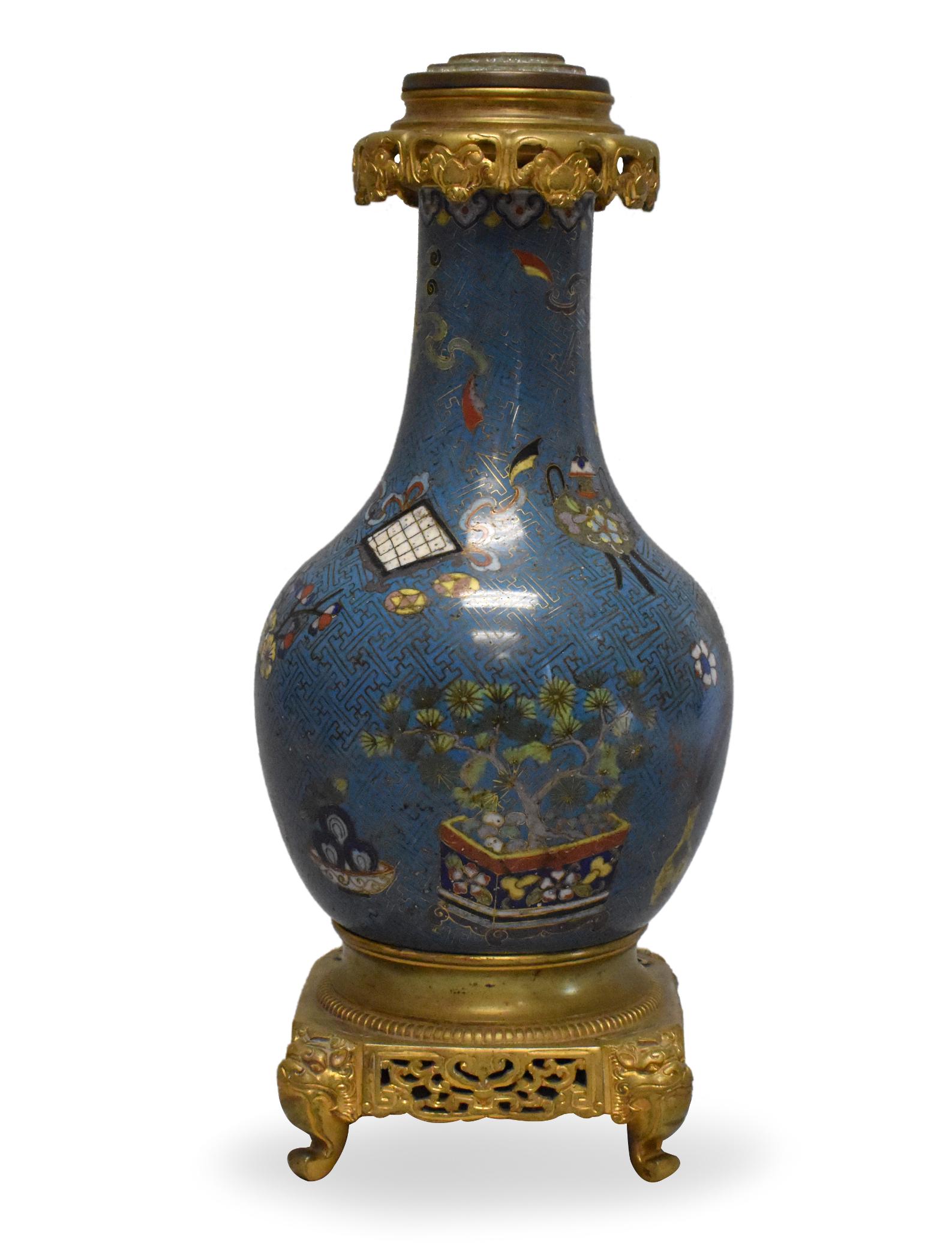 Chinese Mounted Cloisonne Vase w/ Antiques,18th C.: A Chinese cloisonne vase mounted on a metal stand., dating from the 18th century. Also an ornate gilded covering over the rim that extends outward as an umbrella over the neck. The design of the clois