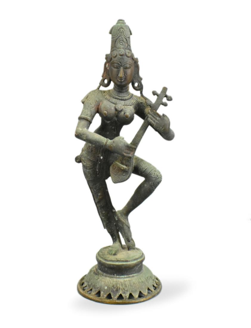 Indian Bronze Carved Buddha Figure, 19th C.: An Indian bronze carved buddha figure, dating from the 19th century. The animated figure balances on one foot, with the other leg bent, as she plays a long necked string instrument. She wears and orna
