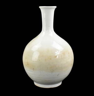 Korean White Glazed Vase,17th C.: A Korean white glazed vase, dating from the 17th century. elegant vase with rounded body curving to a narrow neck and to a flared mouth rim. standing on a stout round foot. covered with milky white gl