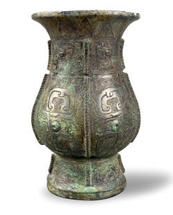 Chinese Ritual Bronze Vessel (Zhi),Shang Dynasty: A Chinese archaic ritual broze Zhi vase, dating from the Shang dynasty (1600-1045 BC). the pear shaped body rising from a tall splayed foot to a flaring mouth, cast on each side of the body with a tao