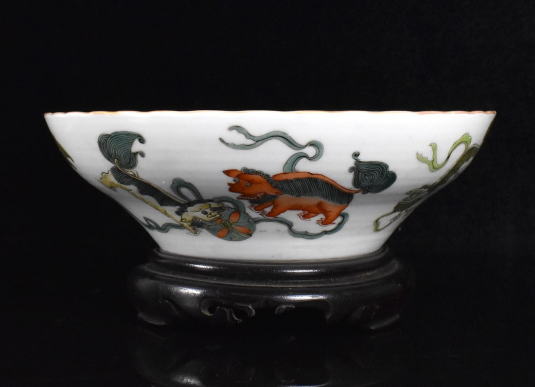 Chinese Famille Rose Bowl w/ Foo Lions, 19th C.: A Chinese famille rose bowl with foo lion on wooden stand. dated from 19th C. The center is decorated with three small pink delicate flowers, the exterior with three colorful groupings of male and fem