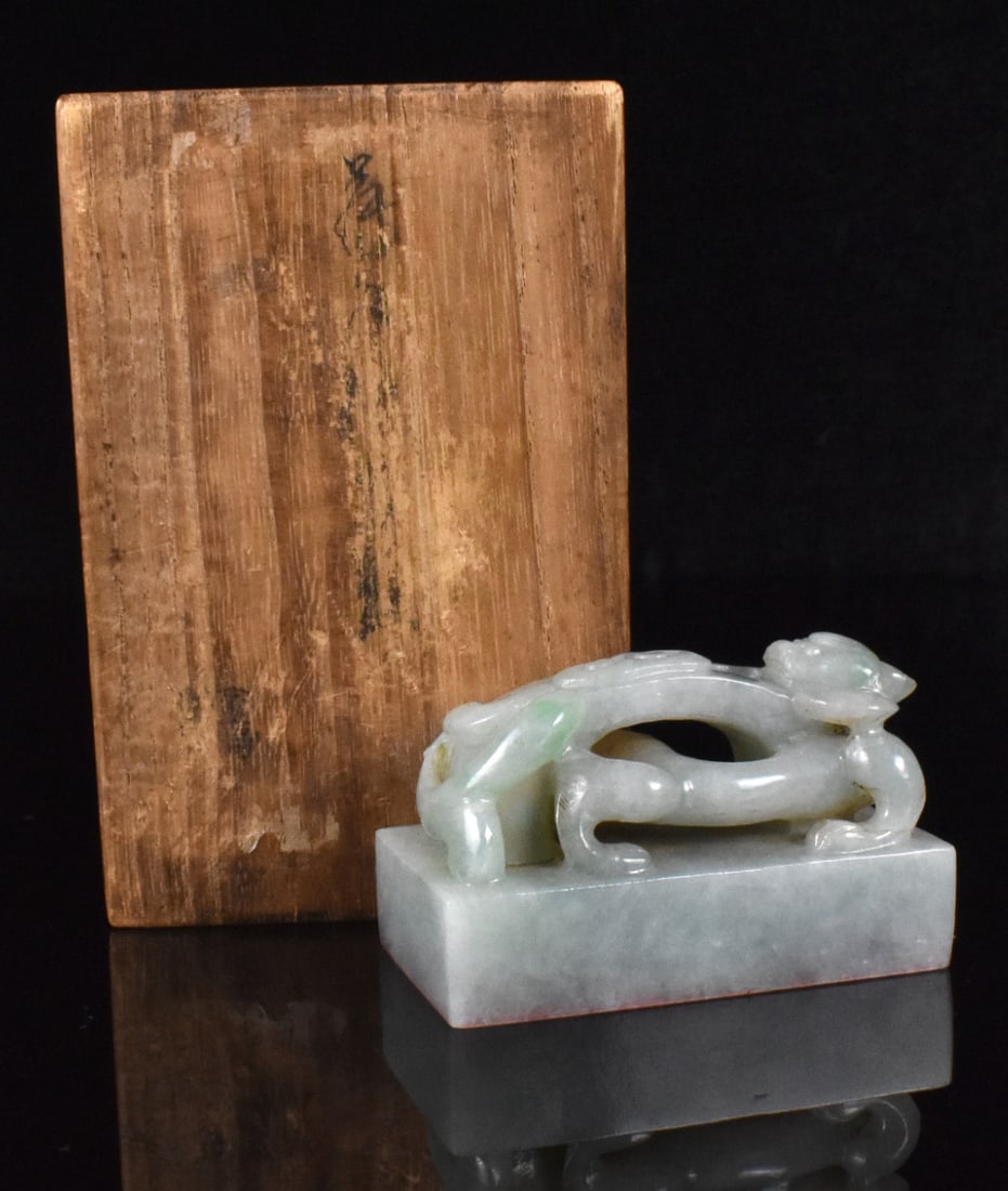 Chinese Jadeite Carved Seal, Qing Dynasty: A Chinese jadeite seal in a wooden box. dated from Qing Dynasty, A rectangular seal with a chi-dragon raised from the block, its head facing backward holding a lingzhi mushroom in its mouth. incised w