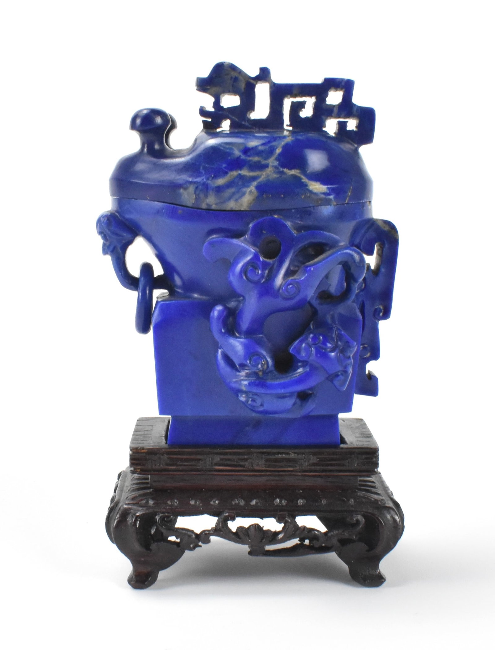 Chinese Lapis Carved Archaic Covered Vase,19th C.: small lapis dark blue carved vase with archaic theme, two dragons swirling on each sides and stylized dragon handle on vase and cover, Accompanied by a two tier carved wooden stand. overall H: 4"(10.2