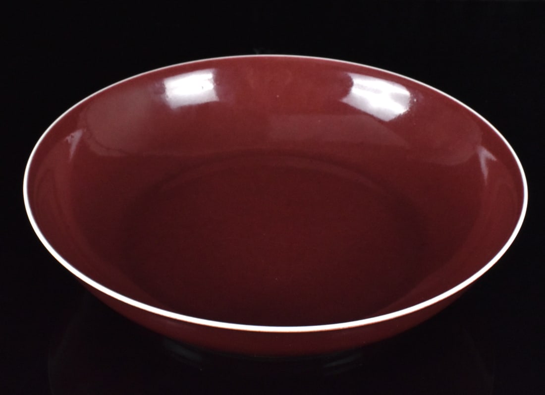 Chinese Copper Red Glazed Dish, Jiaqing Period: Chinese copper red glazed dish, Jiaqing Mark and of the period, rounded sides rising from a tapered foot, covered overall in a dark red glaze thinning to white at the rim, the white base with a six re