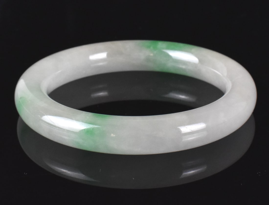 Chinese Jadeite Carved Bangle, Qing Dynasty: A Chinese jadeite carved bangle, dating from the Qing dynasty. Milky white jadeite carved smoothly with some bright green inclusions. D. Interior: 2 1/4" (5.7 cm), Exterior: D. 3 1/8" (7.9 cm) Collect