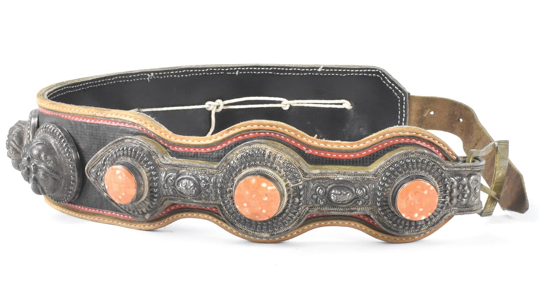 Tibetan Leather Belt w/Silver & Coral,Qing Dynasty: A Tibetan leather belt with silver and coral, dating from the Qing dynasty. Seven repousse circular floral decorations adorn on the belt, with a double circle and arrow form with three inlaid coral pi