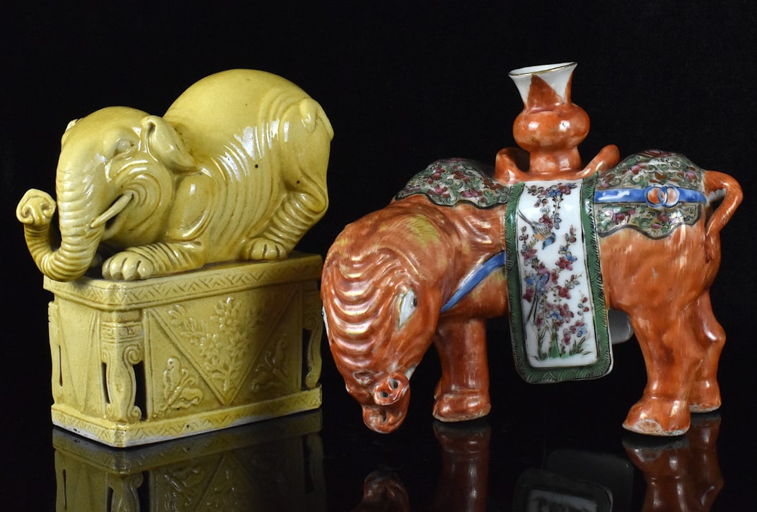 2 Chinese Porcelain Elephant Figures,19th C.: Two Chinese porcelain elephant figures, dating from the 19th century. Yellow glazed elephant is crouched on a rectangular platform with head downwards and trunk curled up. The other famille rose eleph