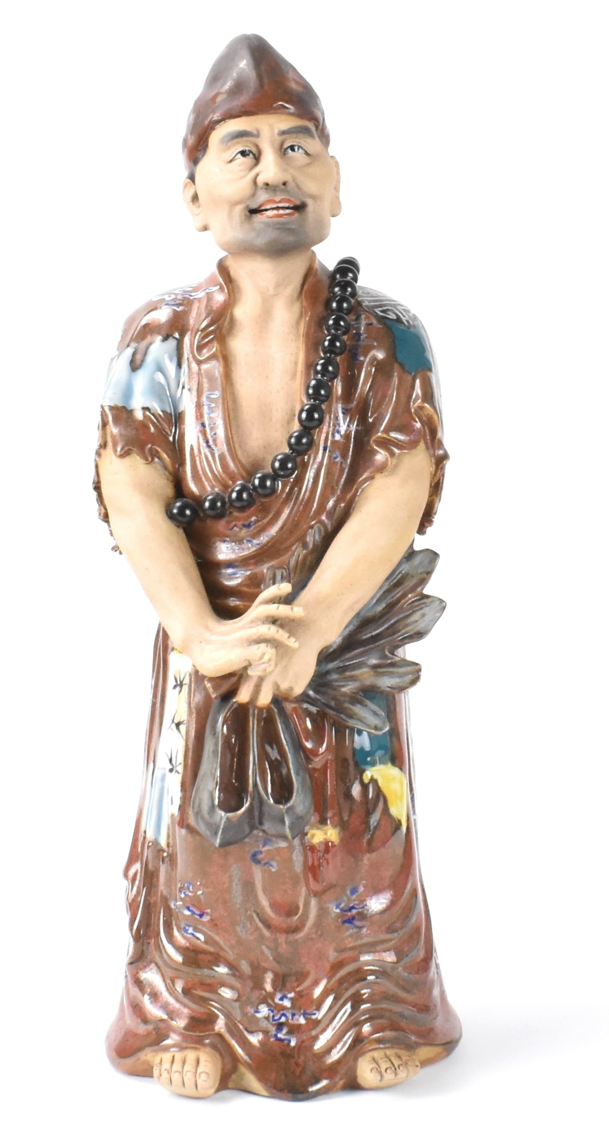 Chinese Famille rose Porcelain Figure, ROC Period: Chinese famille rose porcelain figure, dated from ROC Period, a monk wearing a torn monk robe and hat with beads at the front chest, holding shoes and fan with left hand,standing on barefoot , a horiz