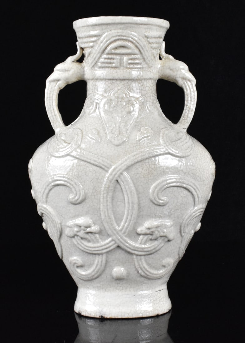 Chinese Soft Paste White Glazed Vase, 18th C.: A Chinese soft paste white glazed vase. dated from 18th C. Oval splayed foot and heart shaped body, with wide shoulder supporting two dragon mouth handles, a wide flared mouth with Shou design under. 