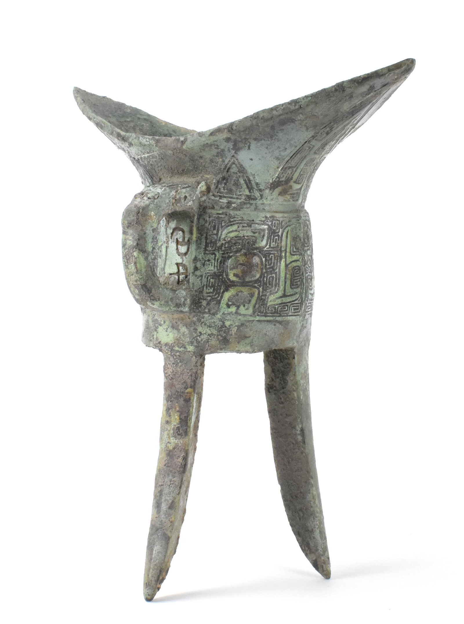 Chinese Inscribed Bronze Vessel(Jiao)Shang Dynasty: A Chinese archaic bronze vessel "Jiao" dating from the Shang dynasty (1600-1045 BC). the deep U shaped body resting on three splayed triangular blade legs, finely cast on each side with a taotie mask 