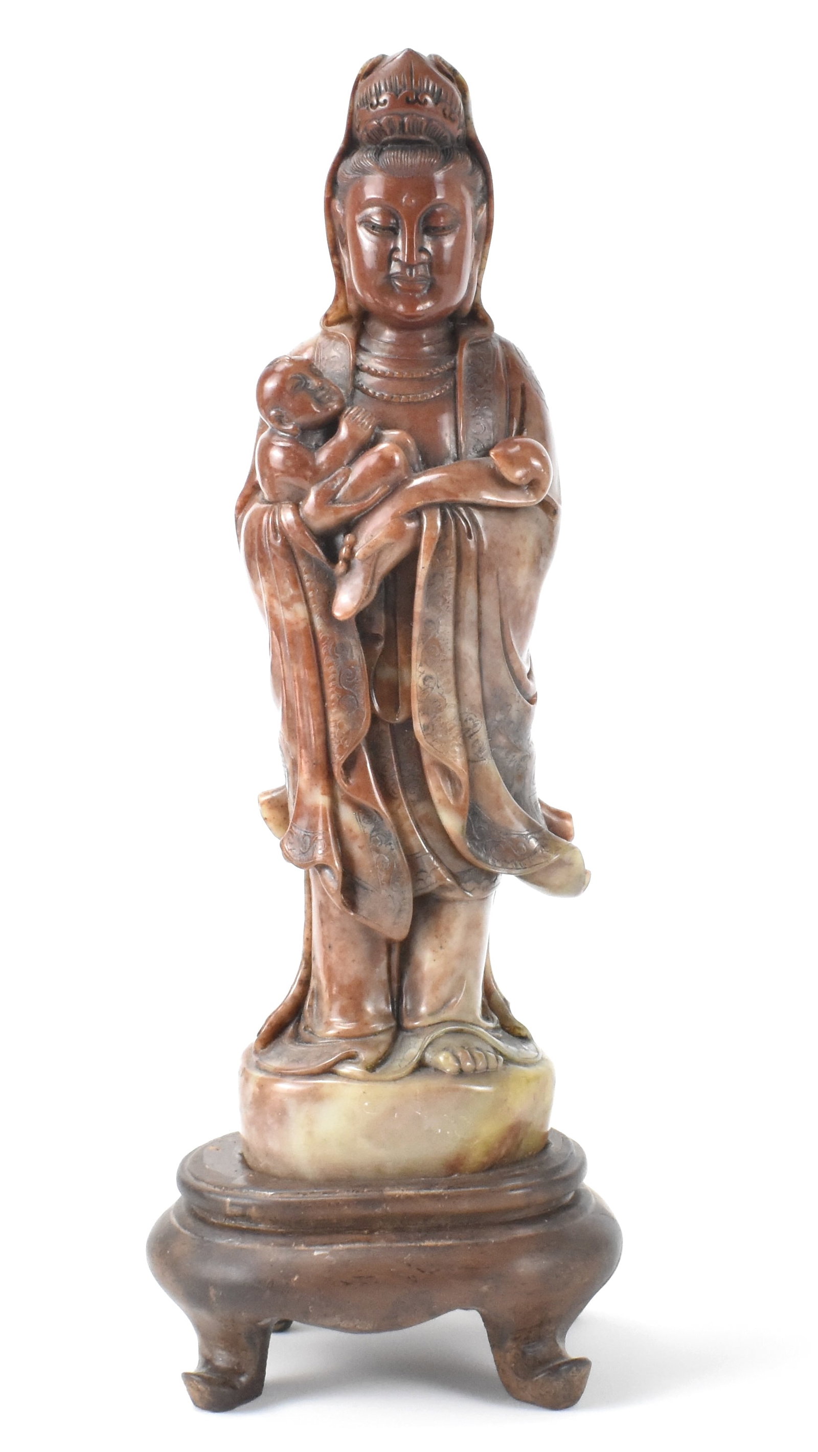 Chinese Soapstone Carved Guanyin, Qing Dynasty: A Chinese soapstone carved Guanyin dating from the Qing dynasty. The Guanyin stands holding a Ruyi Scepter in left hand and baby in right. Her head is cast downwards and eyes lowered. Supported by a w