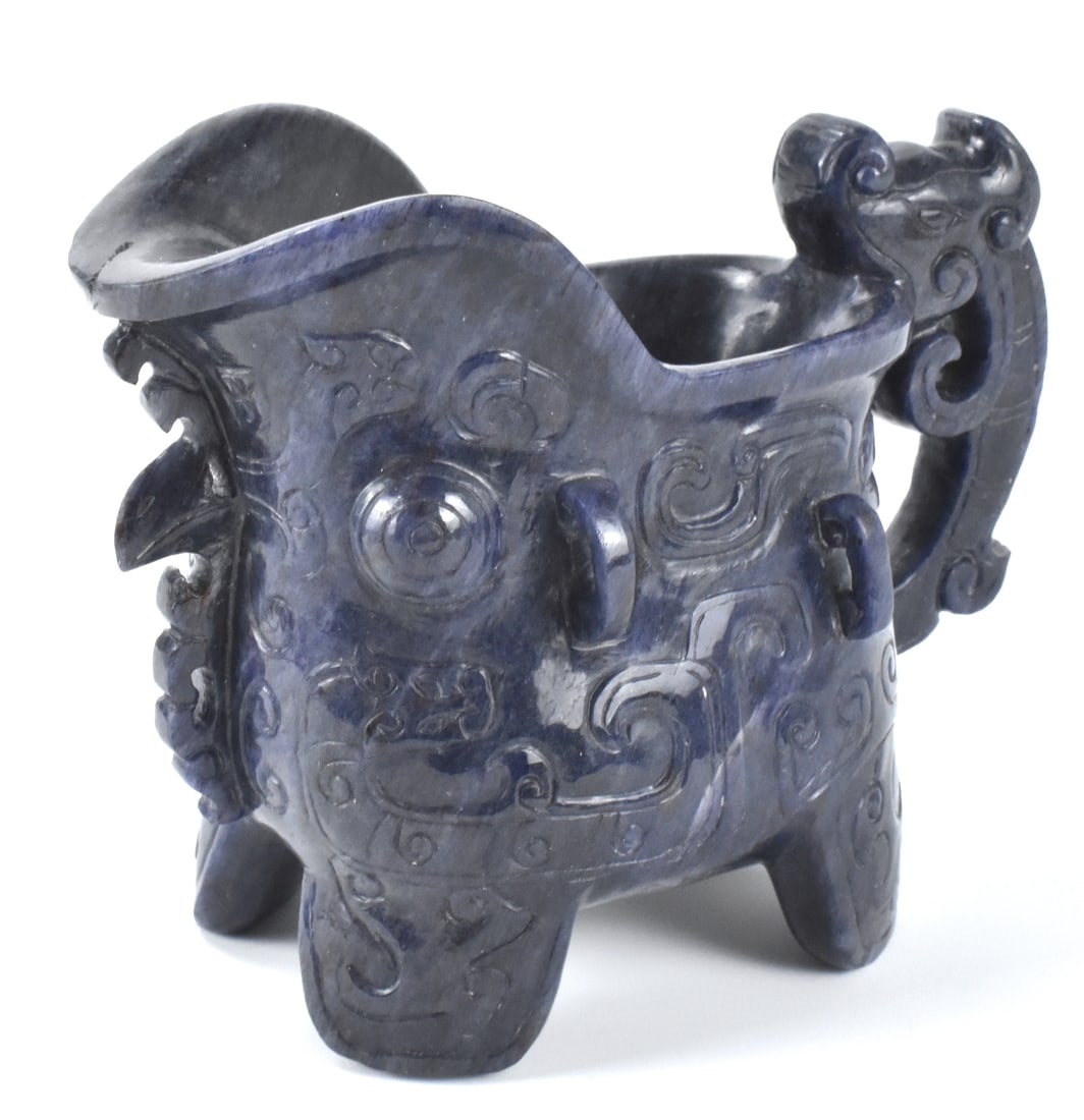 Chinese Archaic Purple Agate Carved Liabition Cup: A Chinese purple carved agate liabition cup. dated from ROC Period, of an archaic design the cup has four stout wide legs and a large, wide, deep spout. dragon handle and incised Taotie design around 
