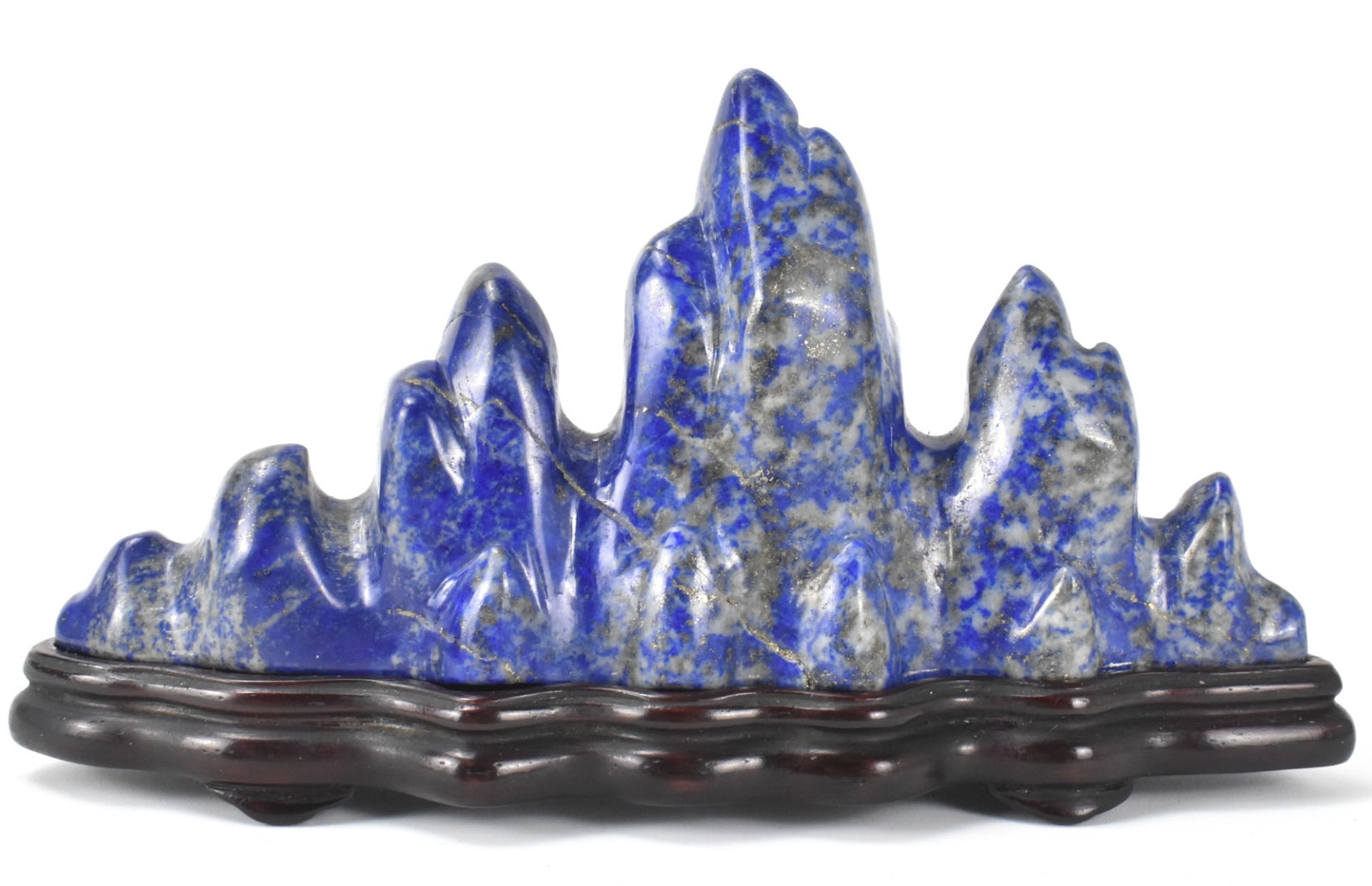 Chinese Lapis Carved Brush Holder on Stand: A Chinese Lapis Carved brush holder on wooden stand. The deep blue lapis has scattered lighter inclusions and is shaped like a mountain range with different level peaks. Accompanied by a custom wooden