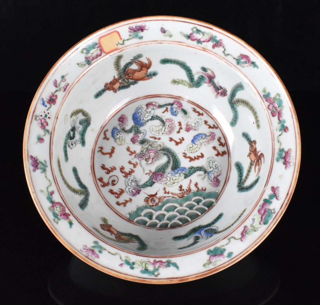 Chinese Famille Rose Dragon Basin, 19th C.: A Chinese famille rose dragon basin dating from the 19th century.in flat center a dragon amongst colorful clouds and waves below. Within a double red circle. gold fish decorate the interior sides and 