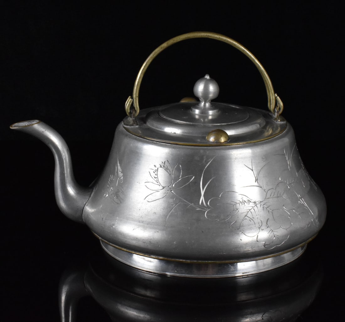 Chinese Pewter Carved Teapot, Qing Dynasty: A Chinese pewter carved teapot, dating from the Qing dynasty. A wide, squat pewter teapot with curved narrow Incised mark on the recessed base. From wide base the teapot curves inwards to a wide, flat