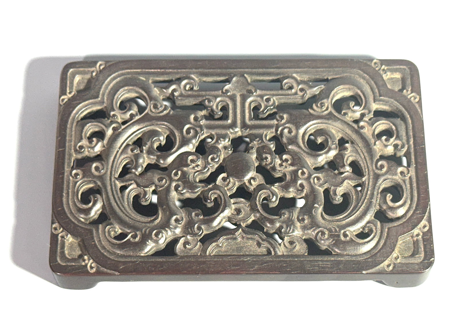 Chinese Carved "Dragon" Wood Stand: A Chinese carved wooden stand with dragon motif. Deeply reticulated carving on the surface of two dragon chasing flaming pearl, of curved decorative forms. L. 4 3/4" (12 cm) Collection of a private Au
