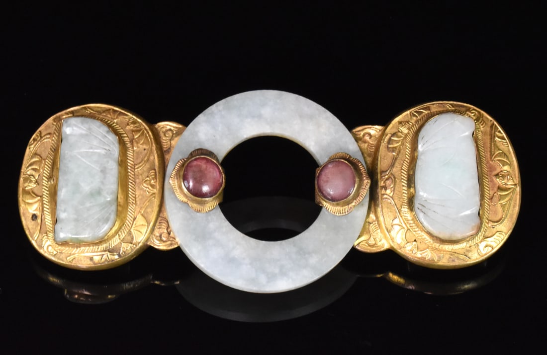 Chinese Gilt Bronze Belt Buckle w/ Jadeite, 19th C: A Chinese gilt bronze belt buckle with jadeite, dating from the 19th century. A central bi shaped jadeite disc has two gilt bronze attachments, each carved with bats design with a jadeite bat shape pl