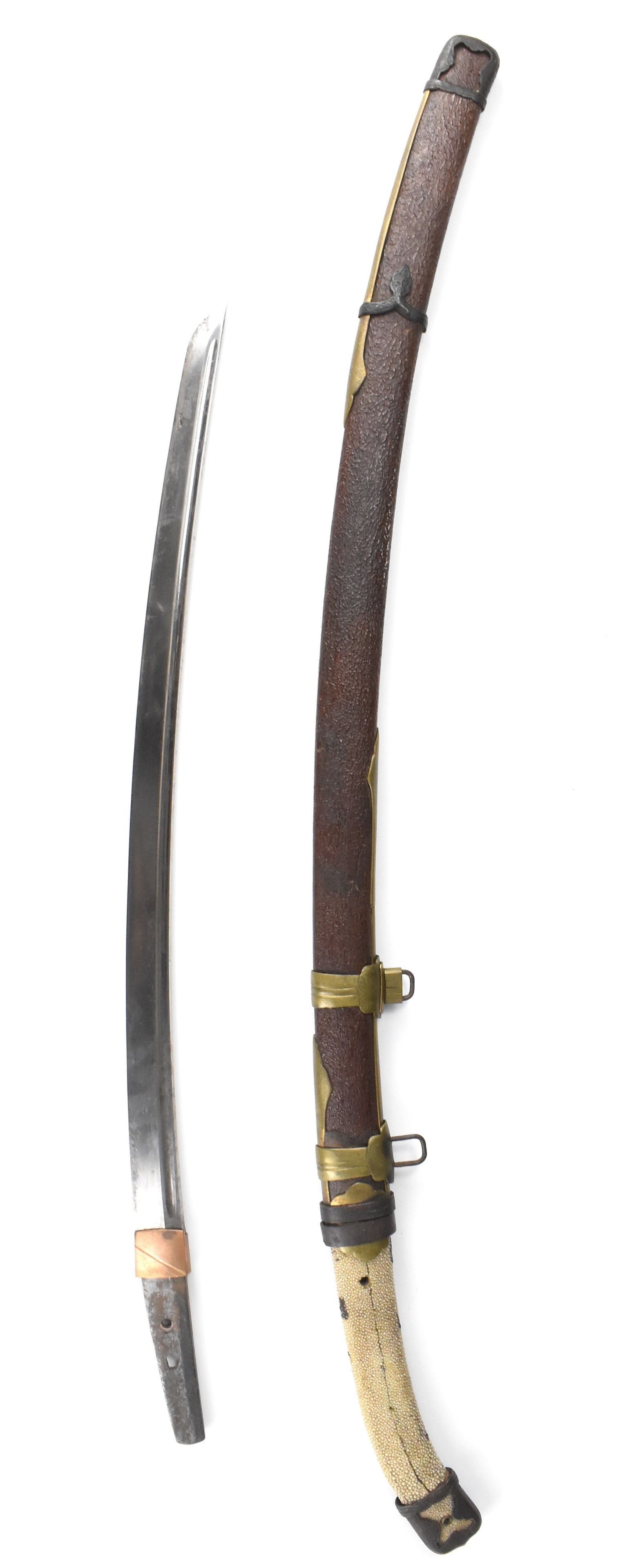 Japanese Wakizashi Sword,17th C.: A Japanese wakizashi sword. The curved sword has an oval shaped tsuba with two thin plates on either side. The curved handle missing its wrap but retains is ray skin. Scabbard has reinforced metal loo