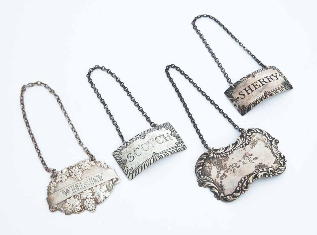 4 FANCY STERLING SILVER BOTTLE TAGS: All marked "STERLING." Includes scotch and sherry by Steiff for Williamsburg, rye, and whiskey (English). Total weight approximately 63g.