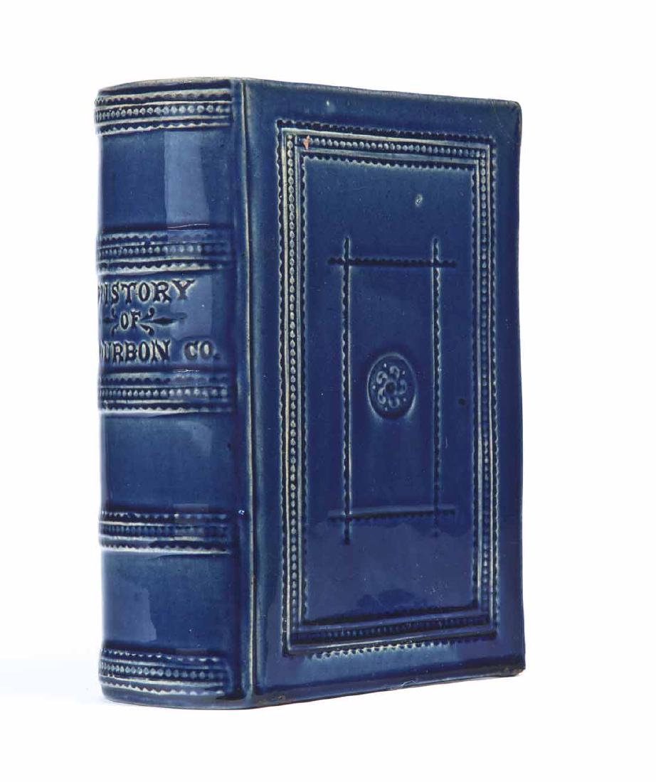 FIGURAL BOOK FLASK: American, 19th century, earthenware. Book-form flask with spine title "HISTORY OF BOURBON COUNTY," and a cobalt blue glaze. 7.25" high.