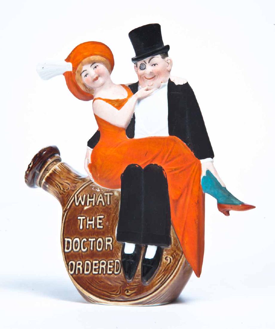 FIGURAL FLASK: German, early 20th century. A party-going couple sitting on "WHAT THE DOCTOR ORDERED." 5.25" high.