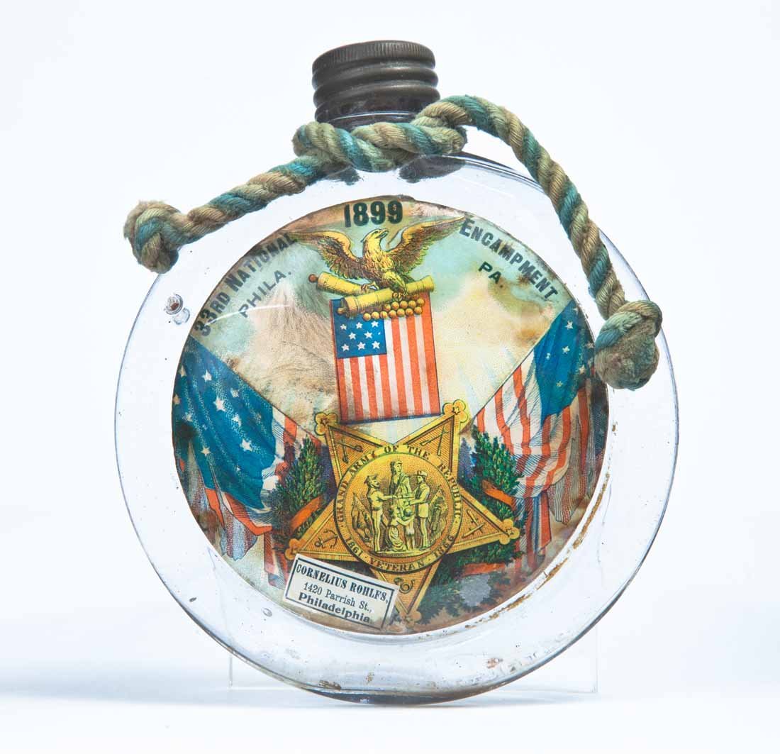 1899 GAR FLASK: Pressed-glass flask with "US" on the reverse," the obverse with an attached lithograph for the 33rd National Encampment in Philadelphia in 1899, and with "CORNELIUS ROHLFS 1420 Parrish St. Philadelphi