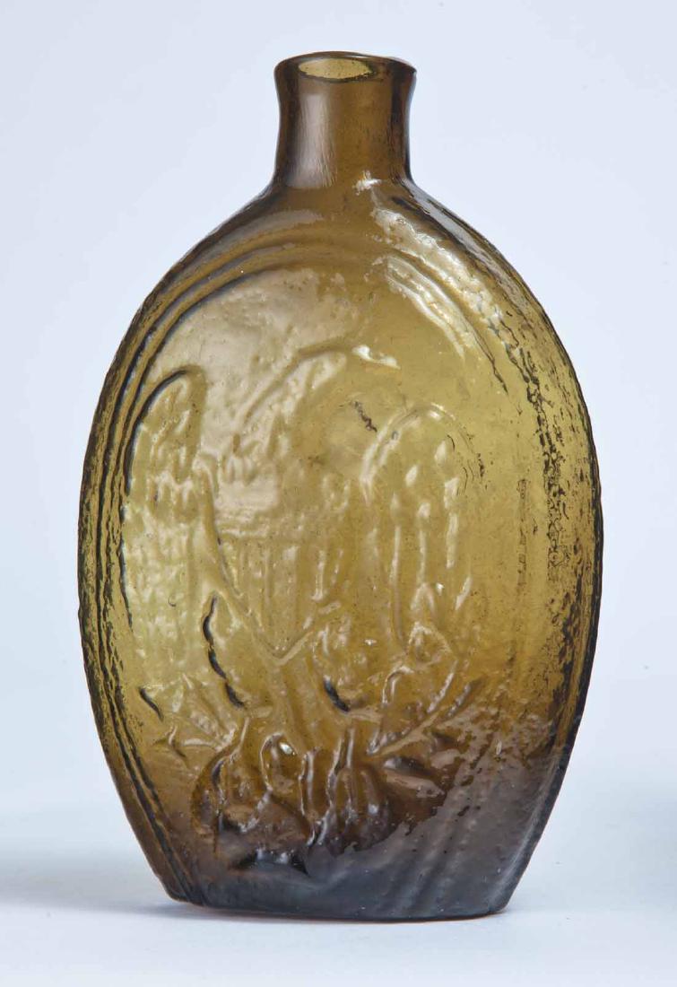 EAGLE & CORNUCOPIA FLASK: GII-73, Keene-Marlboro-Street Glass Works, Keene, NH, mid-19th century, pint, amber in color, with an eagle on the obverse and a cornucopia and "X" on the reverse, plain lip and pontil mark. 6.75" hig