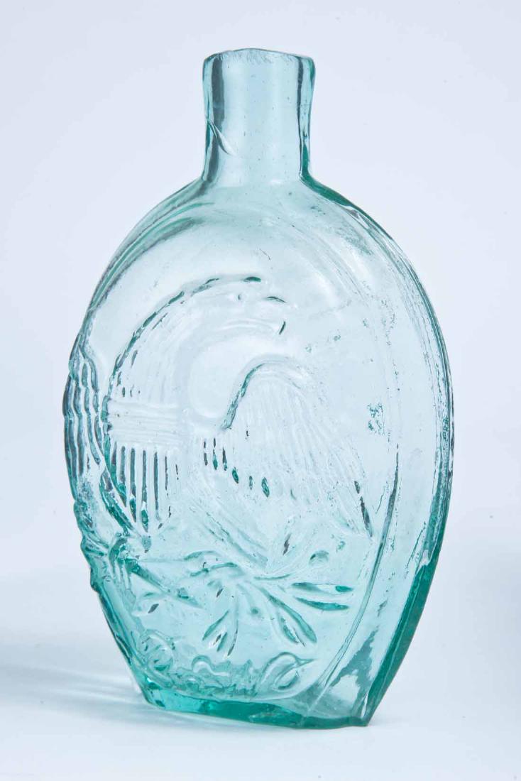 EAGLE & COLUMBIA FLASK: GI-121, American, mid-19th century, pint, aqua in color, with a bust of Columbia wearing a Liberty Cap on the obverse and an eagle and script "B&W" on the reverse, plain lip and pontil mark. 6.75" hig