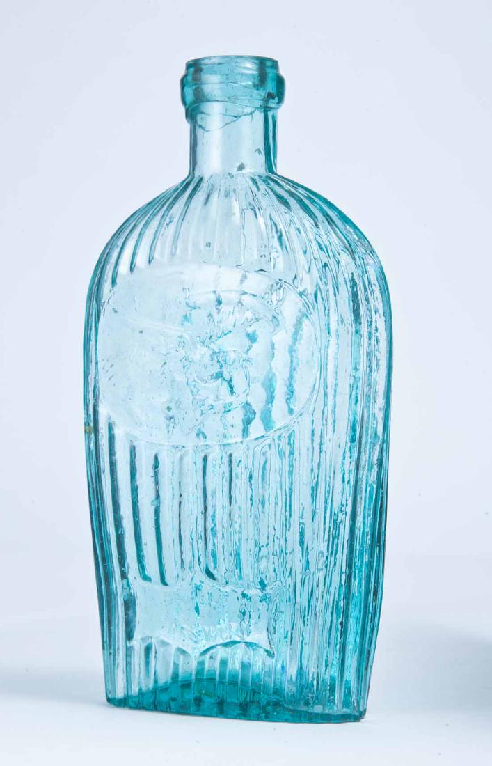 LOUISVILLE EAGLE FLASK: GII-36, Louisville Glass Works, Louisville, KY, mid-19th century, pint, aqua in color, with a ribbed body, and a flying eagle over "LOUISVILLE KY GLASS WORKS" on the obverse. 7.25" high.