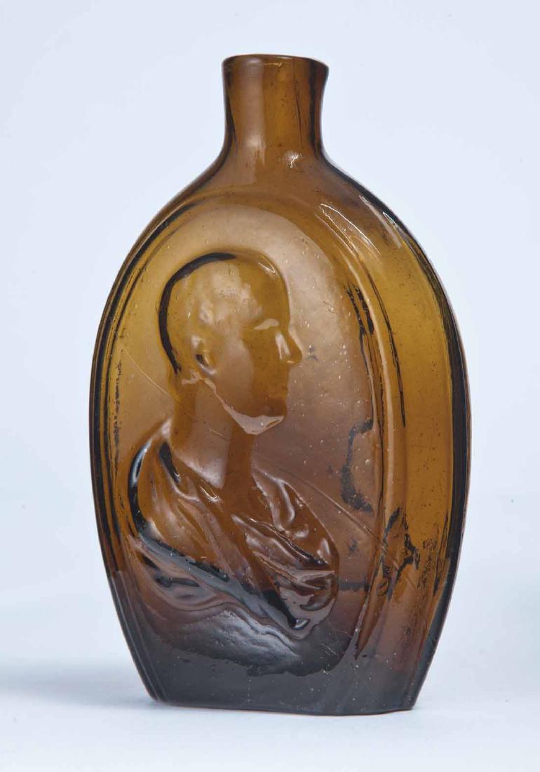 CLASSICAL DRAPED BUST FLASK: GI-114, American, mid-19th century, pint, amber in color, with a draped classical bust on each side (possibly Byron and Scott), plain lip and pontil mark. 5.75" high.