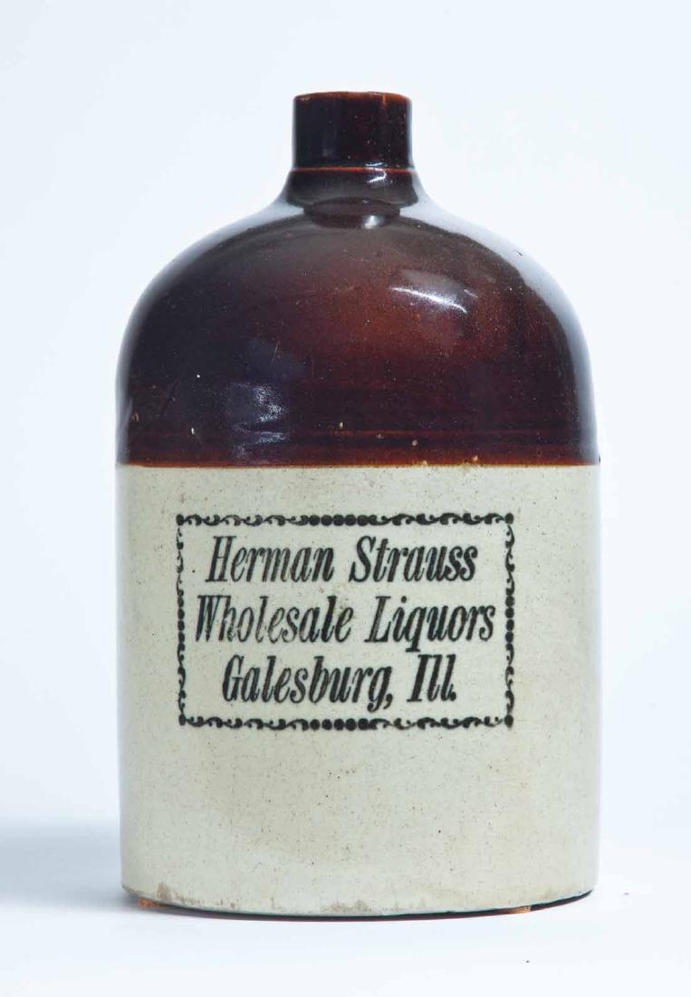 GALESBURG, ILLINOIS ADVERTISING STONEWARE LIQUOR JUG: 1-gallong jug with bicolor glaze and stamped advertisement "Herman Strauss Wholesale Liquors Galesburg, Ill." 11" high.