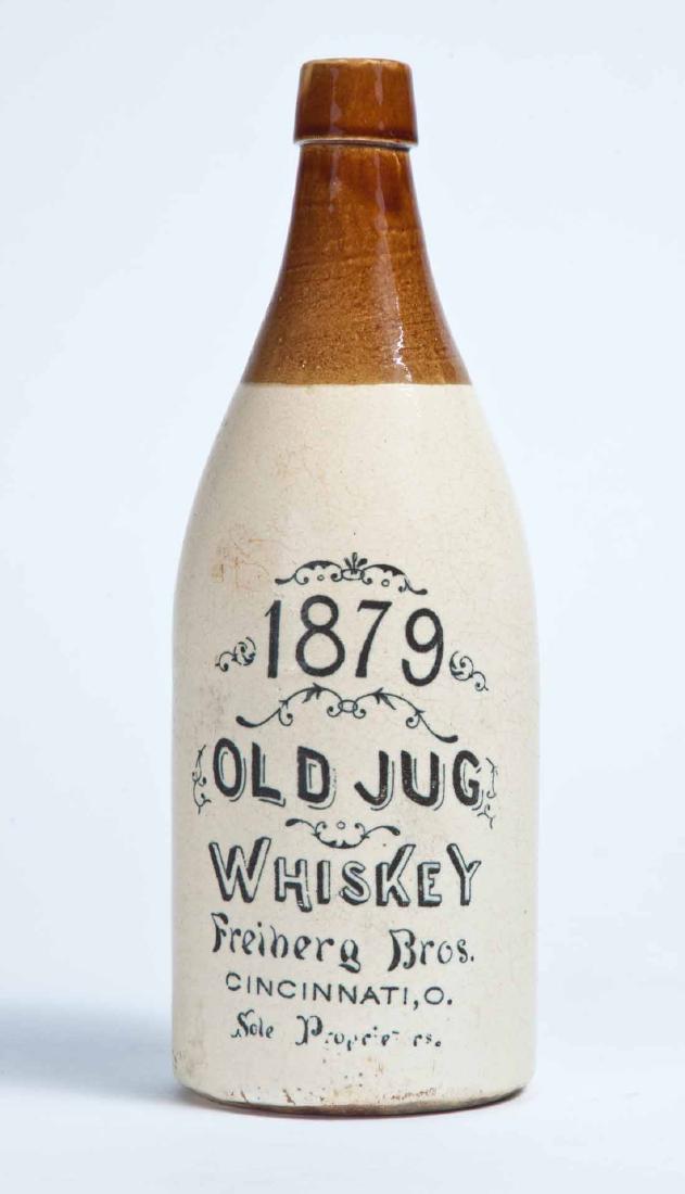 CINCINNATI, OHIO ADVERTISING STONEWARE WHISKEY BOTTLE: 1 quart, with a bicolor glaze and stamped advertisement "1879 OLD JUG WHISKEY Freiberg Bros. CINCINNATI, O. Sole Proprietors." 10.75" high.