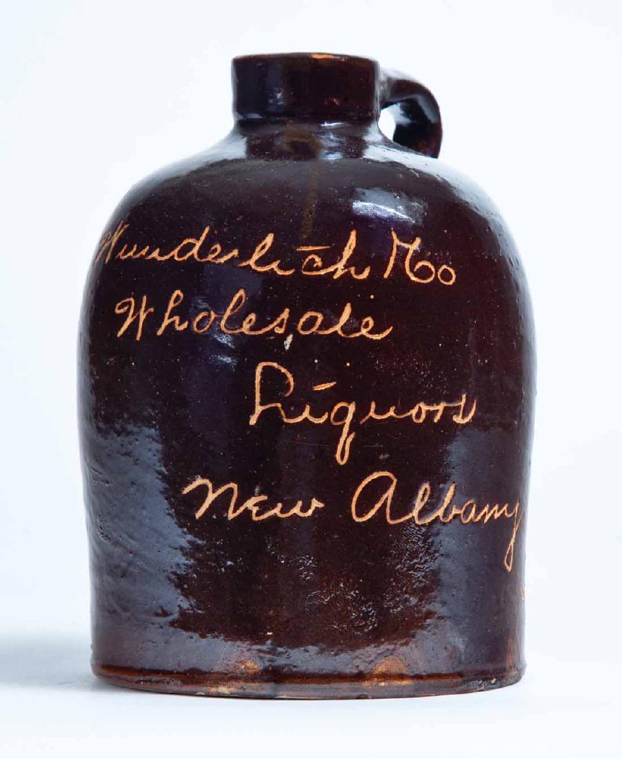 NEW ALBANY, INDIANA ADVERTISING STONEWARE LIQUOR JUG: Small size jug with scratch-decorated advertisement "Wunderlich + Co Wholesale Liquors New Albany, Ind." 6.5" high.