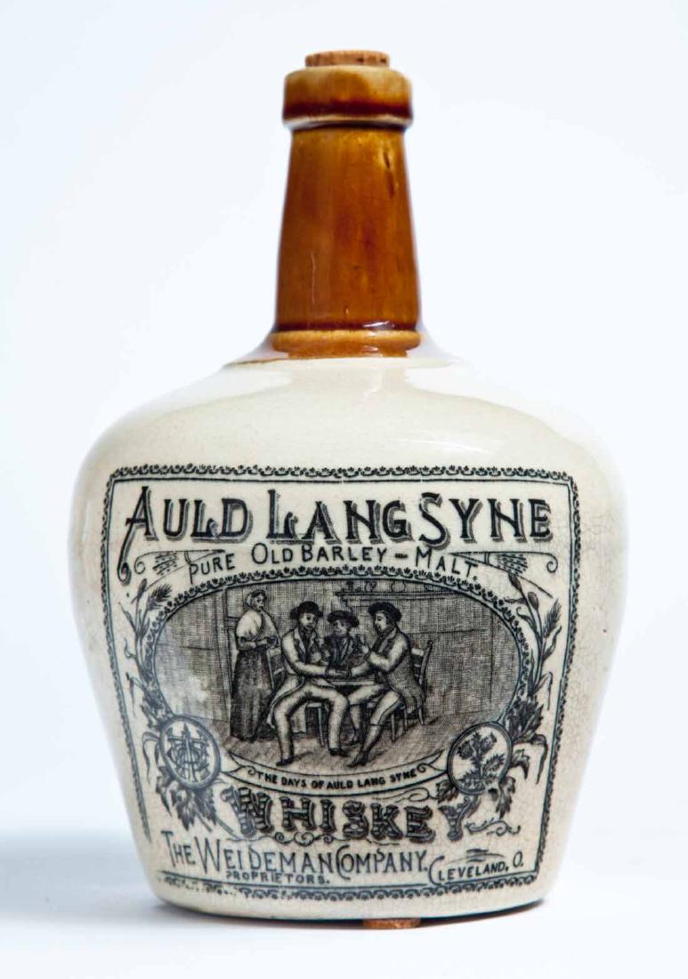 CLEVELAND, OHIO ADVERTISING STONEWARE LIQUOR BOTTLE: Small size jug with a bicolor glaze and double-sided stamped advertising, the front with a tavern scene and "AULD LANG SYNE PURE OLD BARLEY MALT. WHISKEY THE WEIDEMAN COMPANY, PROPRIETORS. CLEVELAND,