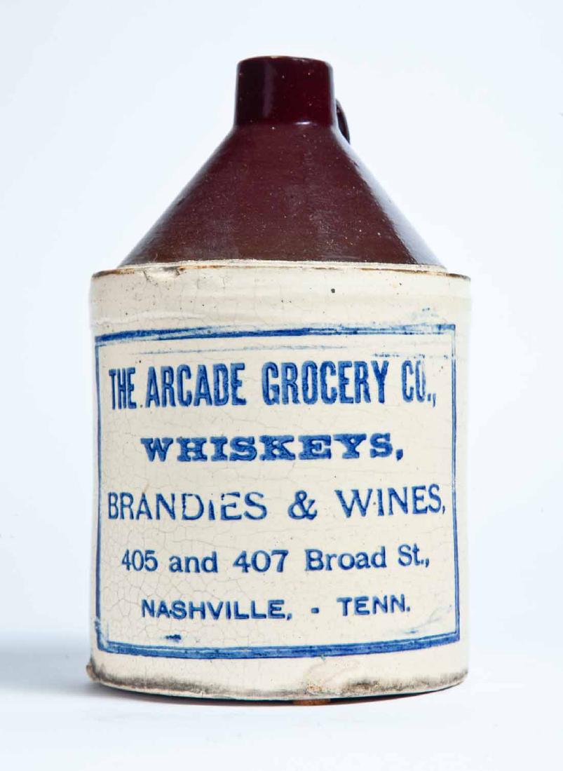 NASHVILLE, TENNESSEE ADVERTISING STONEWARE WHISKEY JUG: Half-gallon jug with bicolor glaze and stamped advertisement "THE ARCADE GROCERY CO., WHISKEYS, BRANDIES & WINES, 405 AND 407 BROAD ST., NASHVILLE, TENN." 9.5" high.