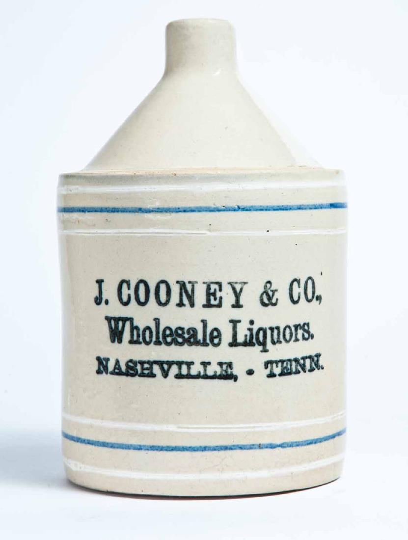 NASHVILLE, TENNESSEE ADVERTISING STONEWARE LIQUOR JUG: Half-gallon jug with cobalt and white striping and stamped advertisement "J. COONEY & CO. Wholesale Liquors. NASHVILLE, TENN." 8.75" high.