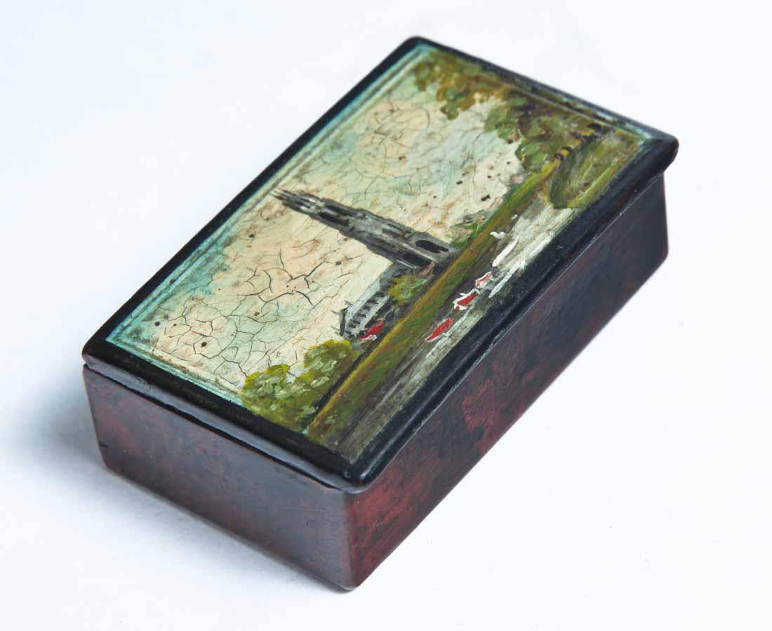 LACQUERWARE SNUFF BOX: Rectangular with hinged lid and painted countryside scene of church and boats on a river. .75"h. 2.5"w. 1.5"d.