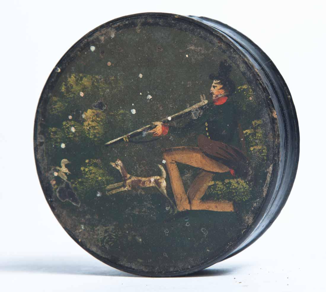 PAINT-DECORATED LACQUERWARE SNUFF BOX: Round with painted scene of a hunter and dog. Purchased from Garth's Auctions, Delaware, Ohio, 1/6/89. .75"h. 2"dia.