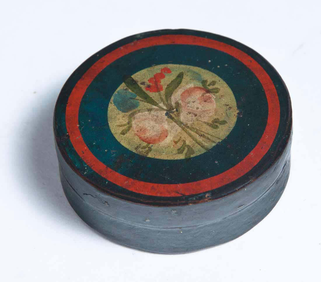 PAINT-DECORATED LACQUERWARE SNUFF BOX: Round with floral decoration on lid inside dark blue and red rings. Purchased at Garth's Auctions, Delaware, Ohio. .75"h. 2.5"dia.