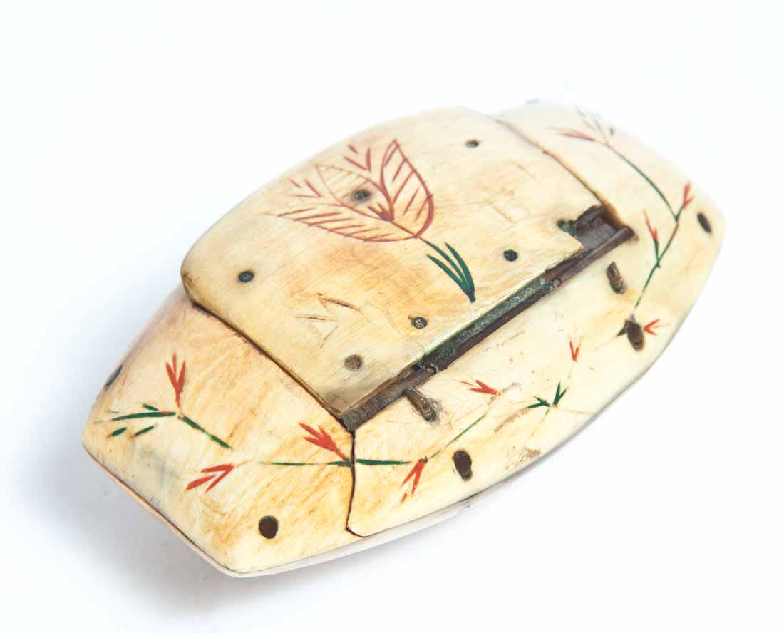 SCRIMSHAW SNUFF BOX: Oval with flattened ends, hinged lid and green and red accents in carved floral lines. Carved initials "MB" on lid. Ex - Tom and Carolyn Porter, sold at their auction at Garth's Auctions, 2004. 1"h. 3