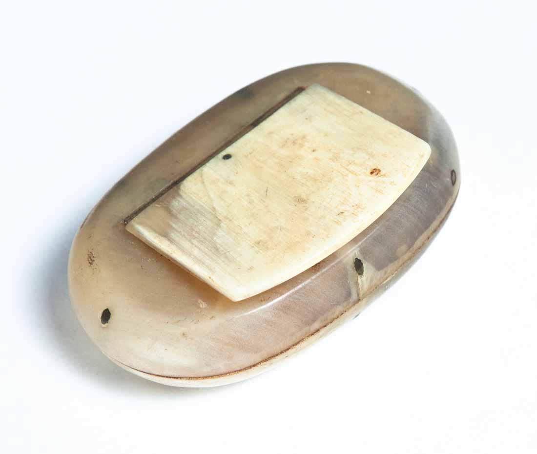 CARVED HORN SNUFF BOX: Oval with nailed construction and hinged lid. Purchased at Garth's Auctions, Delaware, Ohio. .5"h. 2.5"w. 1.5"d.