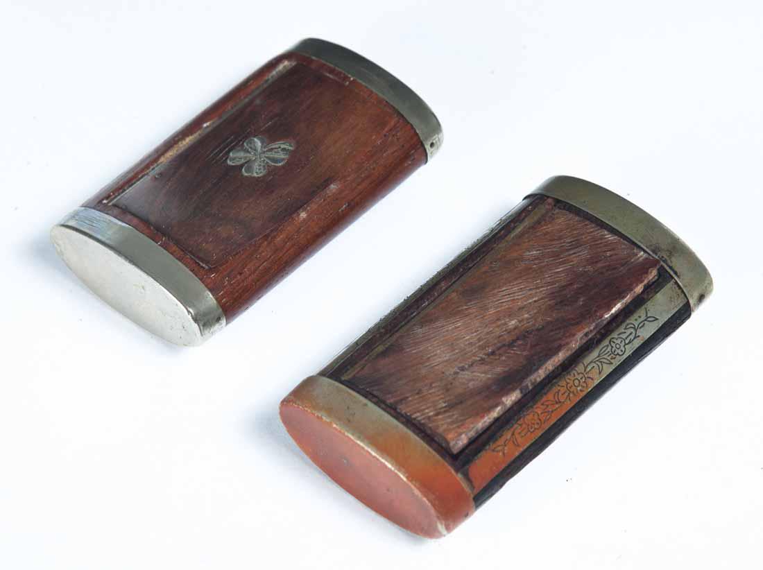 TWO WOOD SNUFF BOXES: Both rectangular with rounded ends. One with inlaid four leaf clover on lid. 2 .75"w. One with engraved floral decoration on metal accents. 3"w.