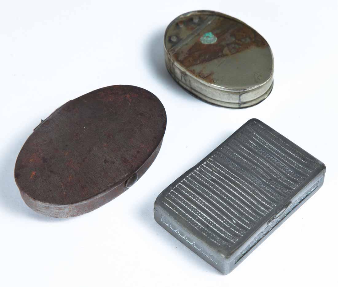 THREE METAL SNUFF BOXES: Two oval, one tin, one pewter. 2"w. 2.75"w. One retangular pewter with embossed lid and sides. 2.5"w.